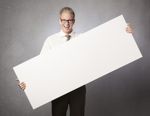 Joyful businessman presenting white blank billboard.