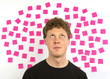 Young man with pink sticky notes question decision making