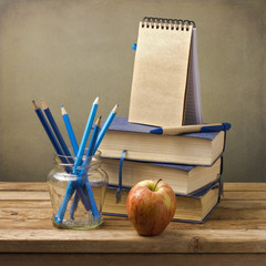 Wall Mural - Old books with pencils, apple and note book on wooden table.