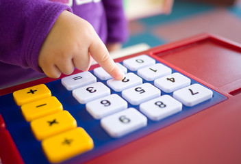 kids finger pressing toy calculator