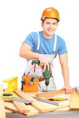 Male worker with a hand drilling machine in a workshop