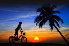 Silhouette Daughter Riding A Bicycle On The Sunset
