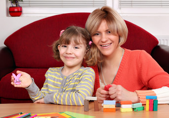 Wall Mural - happy mother and daughter play with plasticine