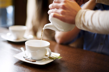 Waitress pouring cup of coffee/tea