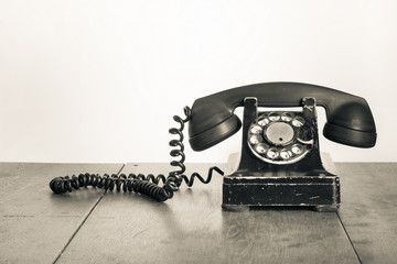 Fototapete - Vintage telephone on old table sepia photo
