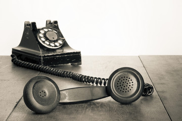 Fototapete - Vintage telephone handset on old table sepia photo