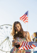 © Mike Kemp/Blend Images - Caucasian woman holding American flags at carnival