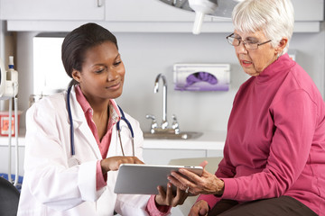 Wall Mural - Doctor Discussing Records With Senior Female Patient