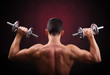 © cristovao31 - Muscular young man lifting weights against black background
