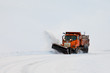 Snow plough clearing road in winter storm blizzard