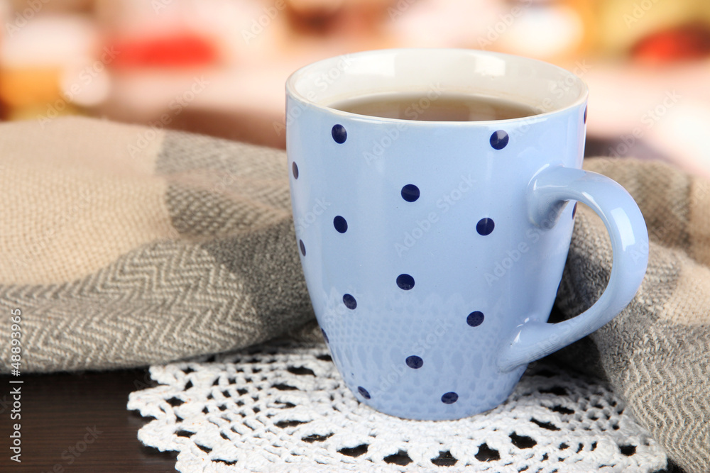 cup of tea with scarf on table in room