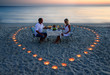 canvas print picture - A young lovers couple share a romantic dinner with candles heart