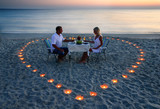 Fototapeta Przestrzenne - A young lovers couple share a romantic dinner with candles heart