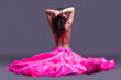 topless dancer in pink costume sitting on floor 