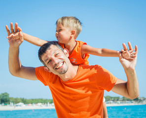 Photo of happy father and son on the beach