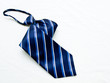 © gururugu - A rolled up striped blue and white tie isolated on white backgro