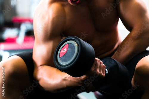 Naklejka dekoracyjna Man at Dumbbell training in gym