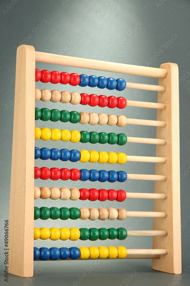 Bright wooden toy abacus, on grey background