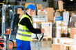 Storeman with mover at warehouse of forwarding