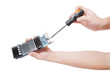 Man's hand repairing video card with  screwdriver.