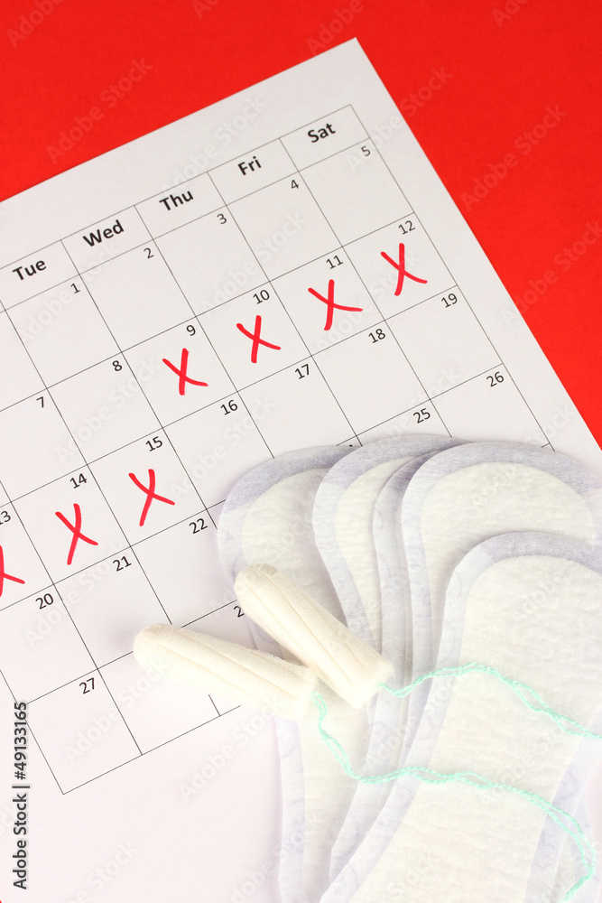menstruation calendar with sanitary pads and tampons, close-up
