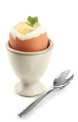 Boiled egg in egg cup, isolated on white