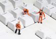 tiny figures of construction engineers removing end key