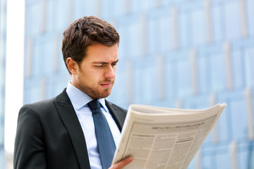 Handsome man reading a newspaper