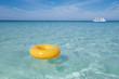 floating ring on blue clear sea with white boat, shallow dof
