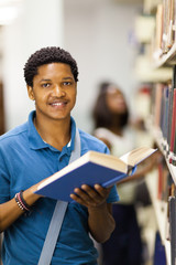 Wall Mural - happy african american college boy reading in library