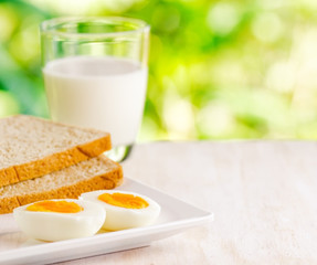 Boiled eggs, toasts and glass of milk