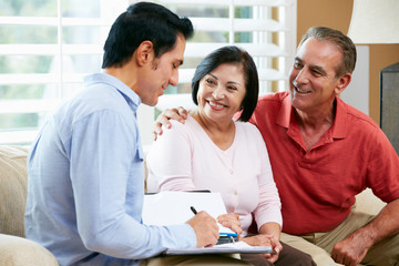 Wall Mural - Financial Advisor Talking To Senior Couple At Home