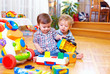 © Olesia Bilkei - two cute baby toddlers playing in nursery room
