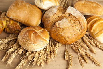 Wall Mural - assortment of fresh baked bread on wood table