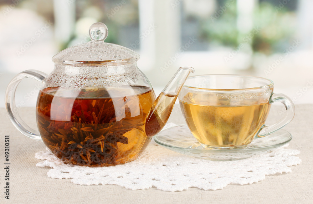 Exotic green tea with flowers in glass teapot