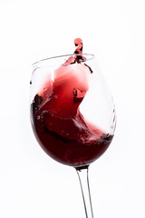 Poster - red wine splashing out of a glass, isolated on white