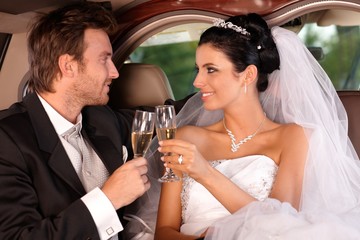 bride and groom clinking glasses