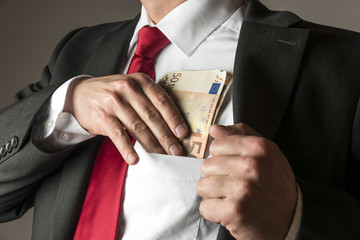 Businessman putting money in pocket