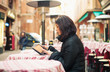 Woman using tablet outdoors sit in a bar. Shallow depth of field