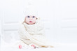 © famveldman - Funny baby in white bedroom and knitted scarf and hat