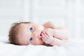 Wall Mural - Adorable blue eyed baby sucking on its fingers