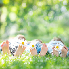 Family with flowers lying on green grass. Healthy lifestyle conc