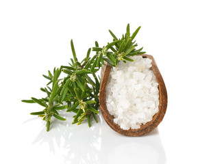 Canvas Print - Salt in a wooden scoop and rosemary on a white background