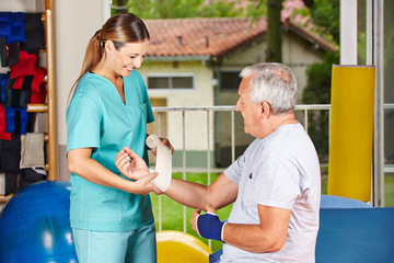 Wall Mural - Krankenschwester bei Physiotherapie wechselt Verband