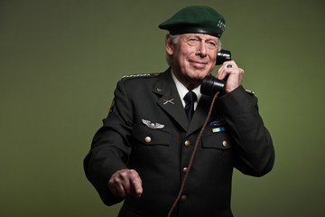 US military general wearing beret. Calling with phone. Studio po