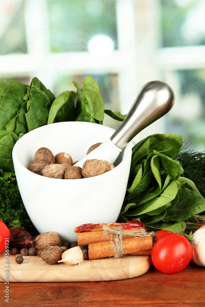 Composition of mortar, spices, tomatoes and  green herbs,