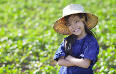 Wall Mural - Little smiling girl farmer on green fields