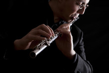 Professional Flutist Musician Playing Flute On Black Background