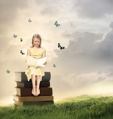 Wall Mural - Little Blonde Girl Reading a Book