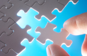 Aufkleber - A person fitting puzzle pieces on blue background.